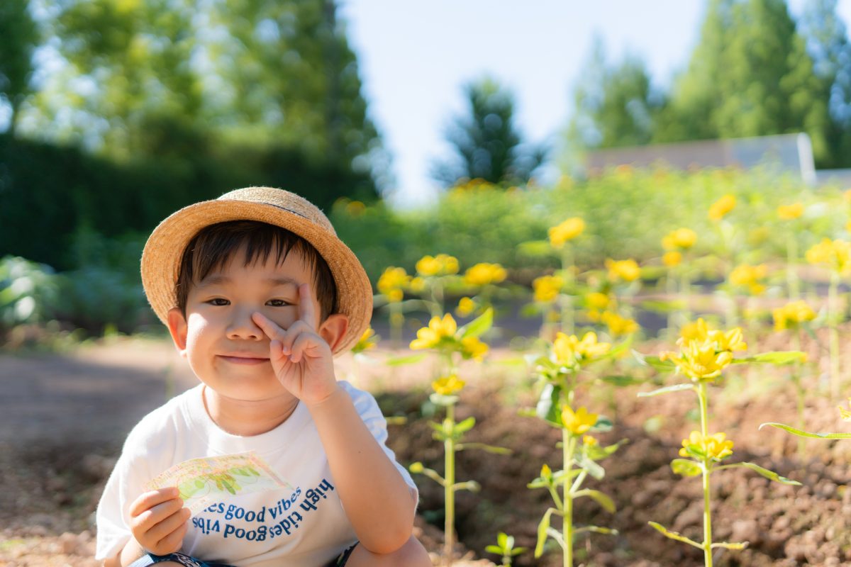 夏の日ざしの中、外あそびで笑っている子どもの様子