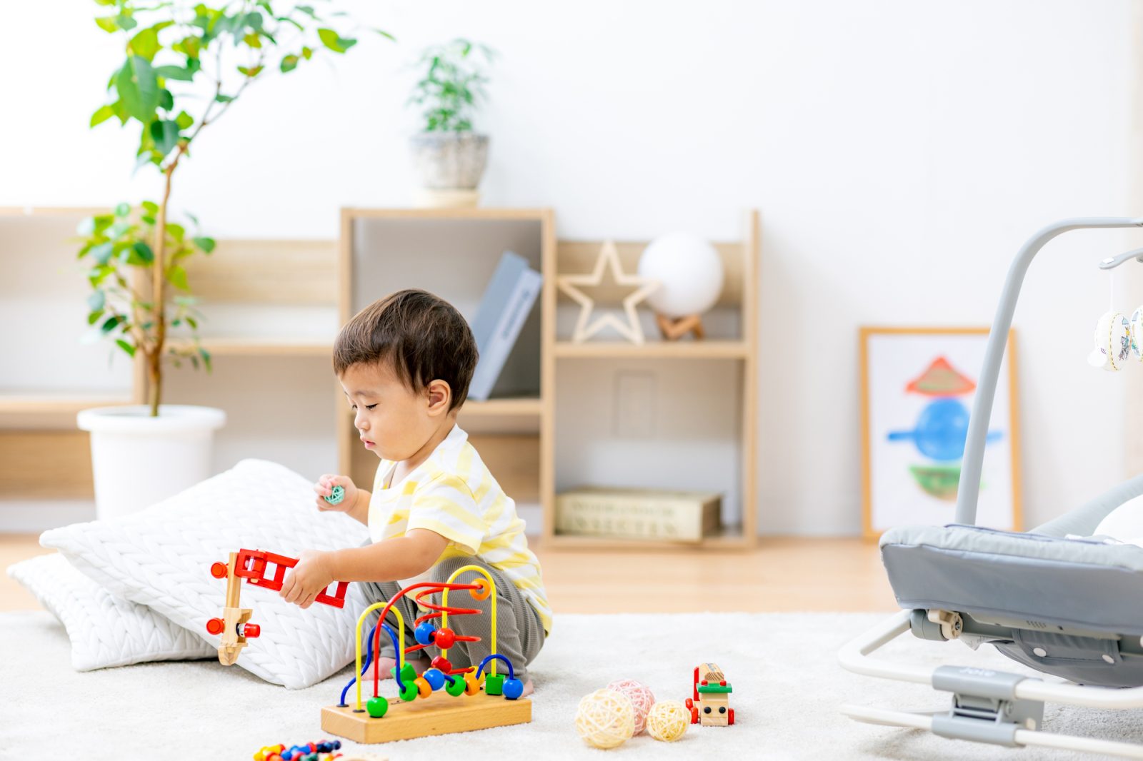 明るい保育室で子どもがおもちゃで遊んでいる様子